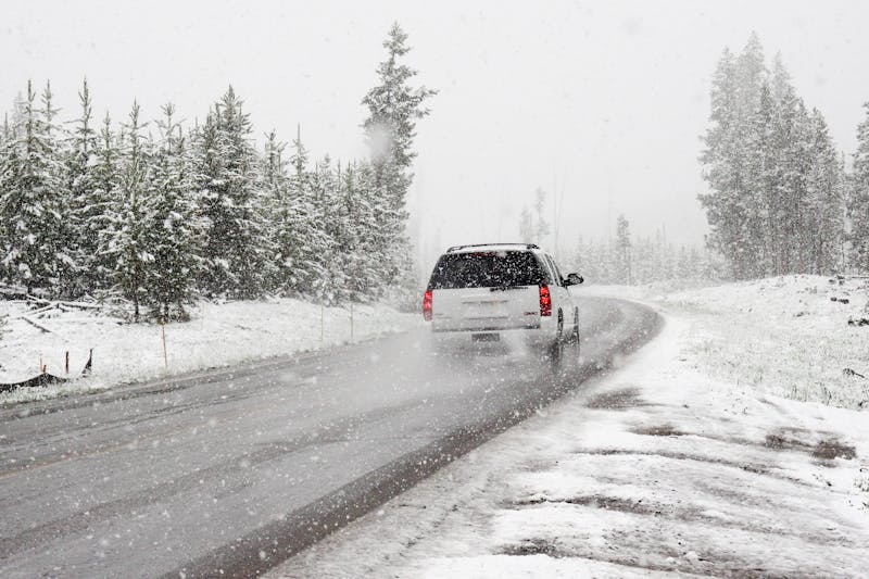 SUV auf verschneiter Straße zwischen schneebedeckten Bäumen – Winterfahrt in Norwegen